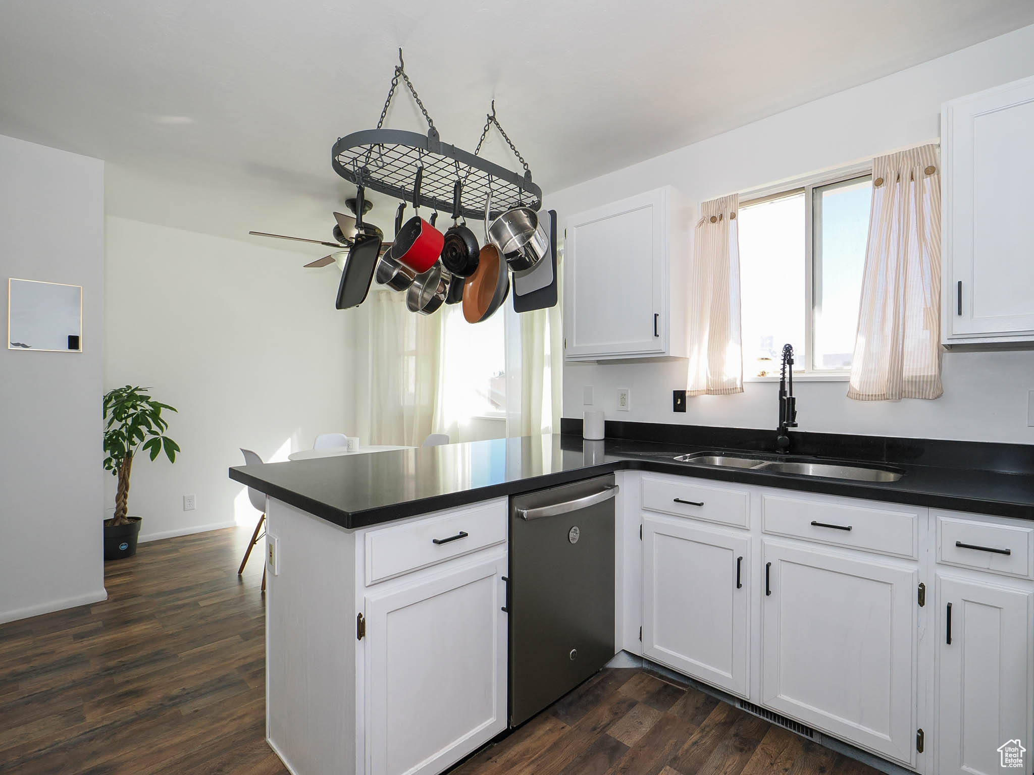 Kitchen with white cabinets, dishwasher, and sink