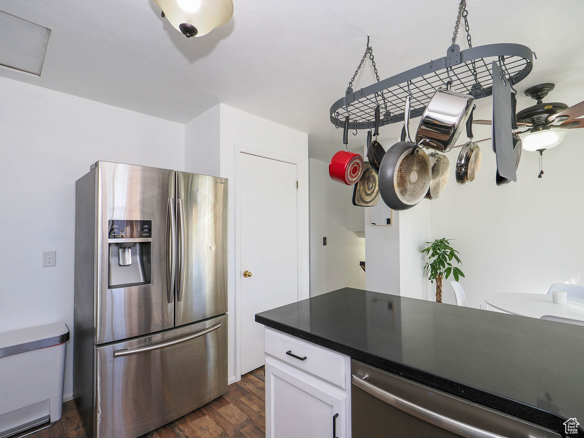 Kitchen with white cabinets, appliances with stainless steel finishes, and dark hardwood / wood-style flooring