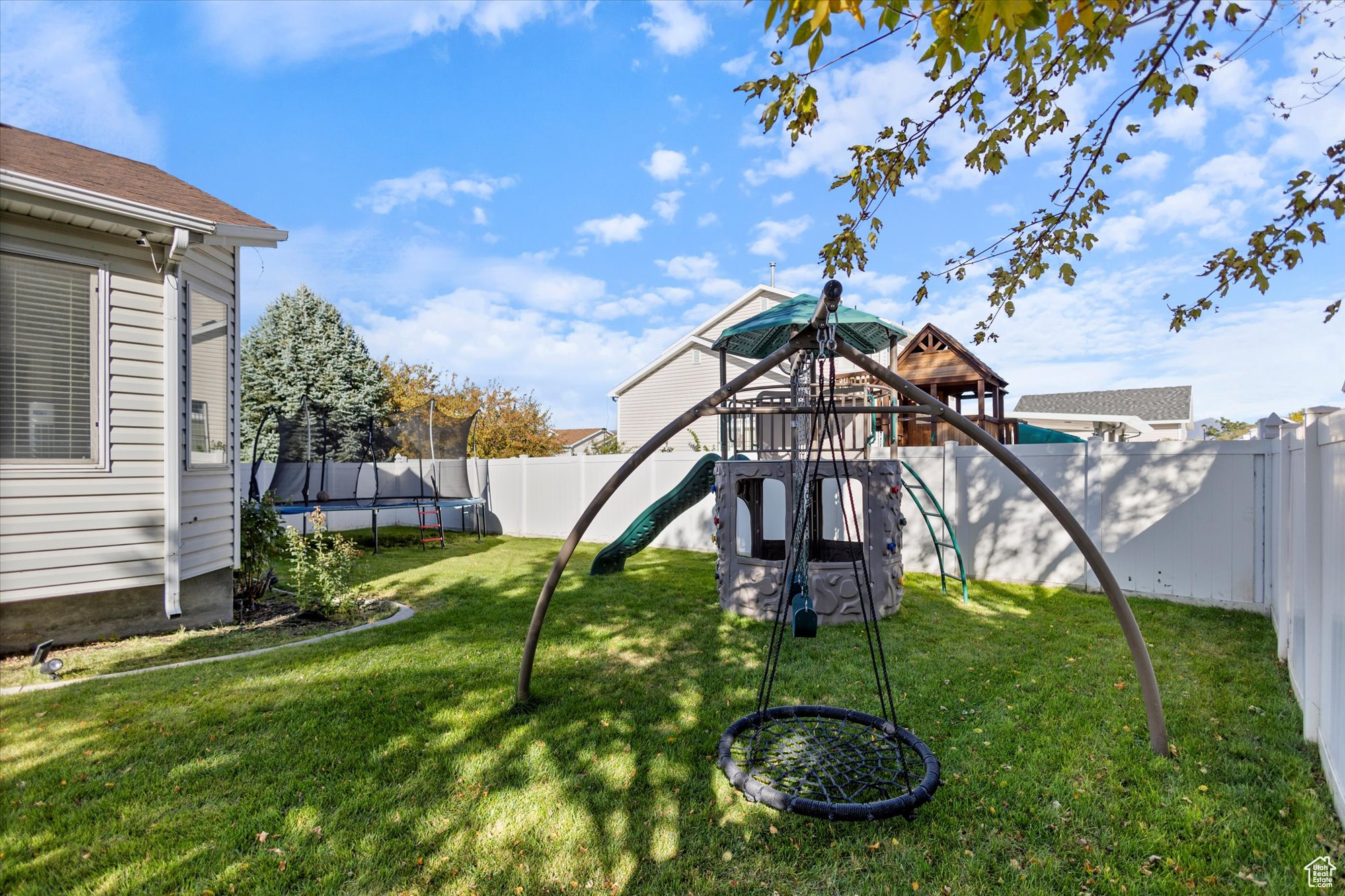 View of yard with a playground and a trampoline