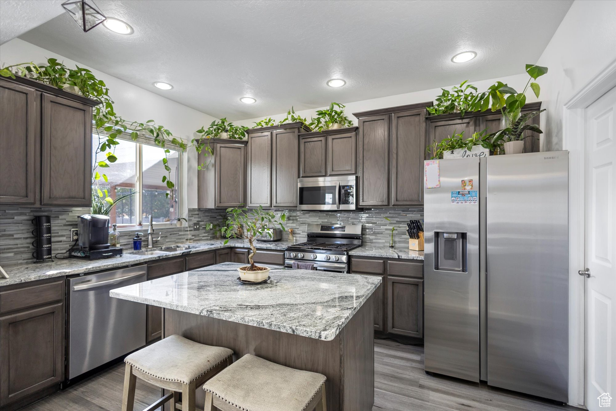 Kitchen featuring decorative backsplash, a center island, and stainless steel appliances