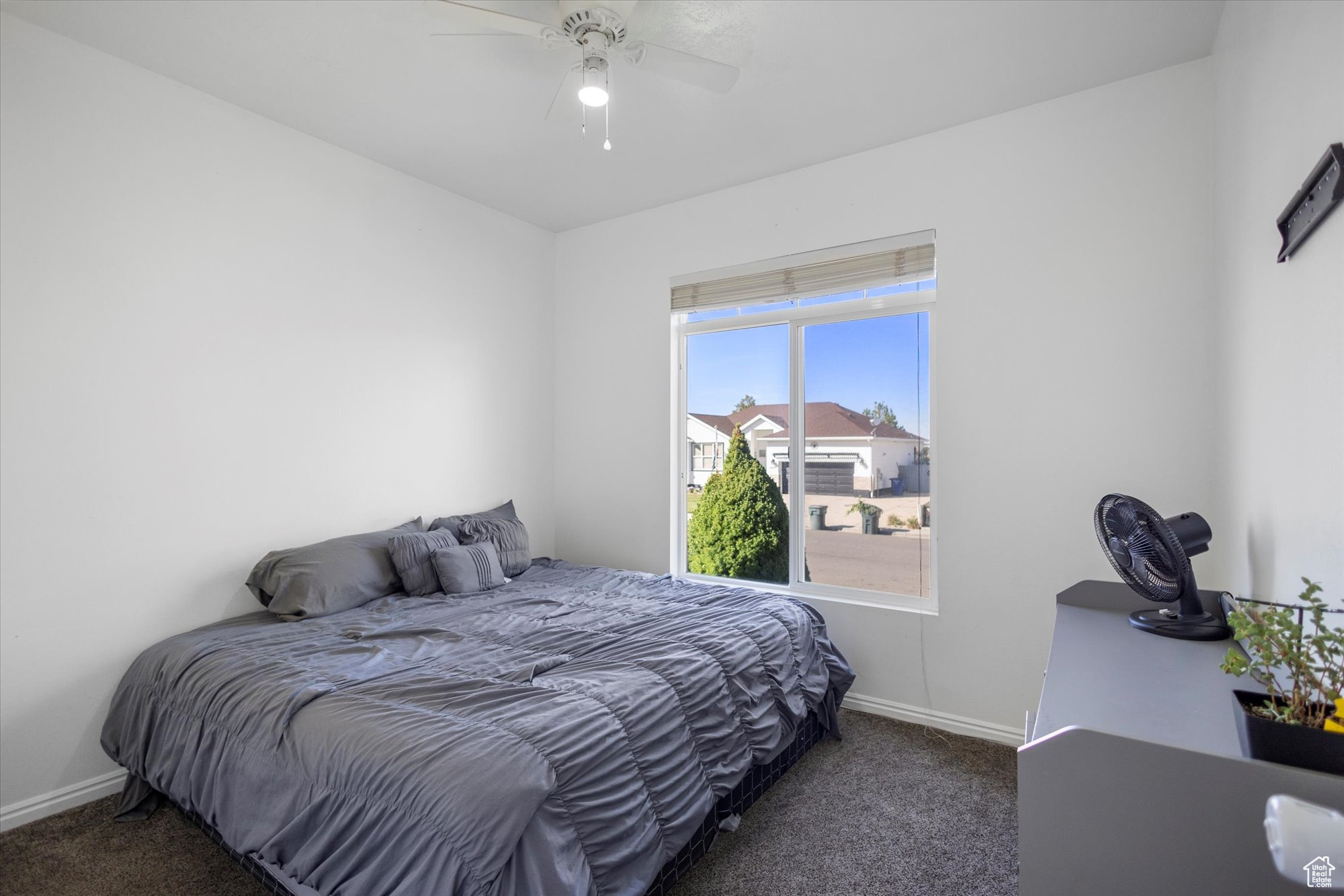 Bedroom featuring ceiling fan and dark colored carpet