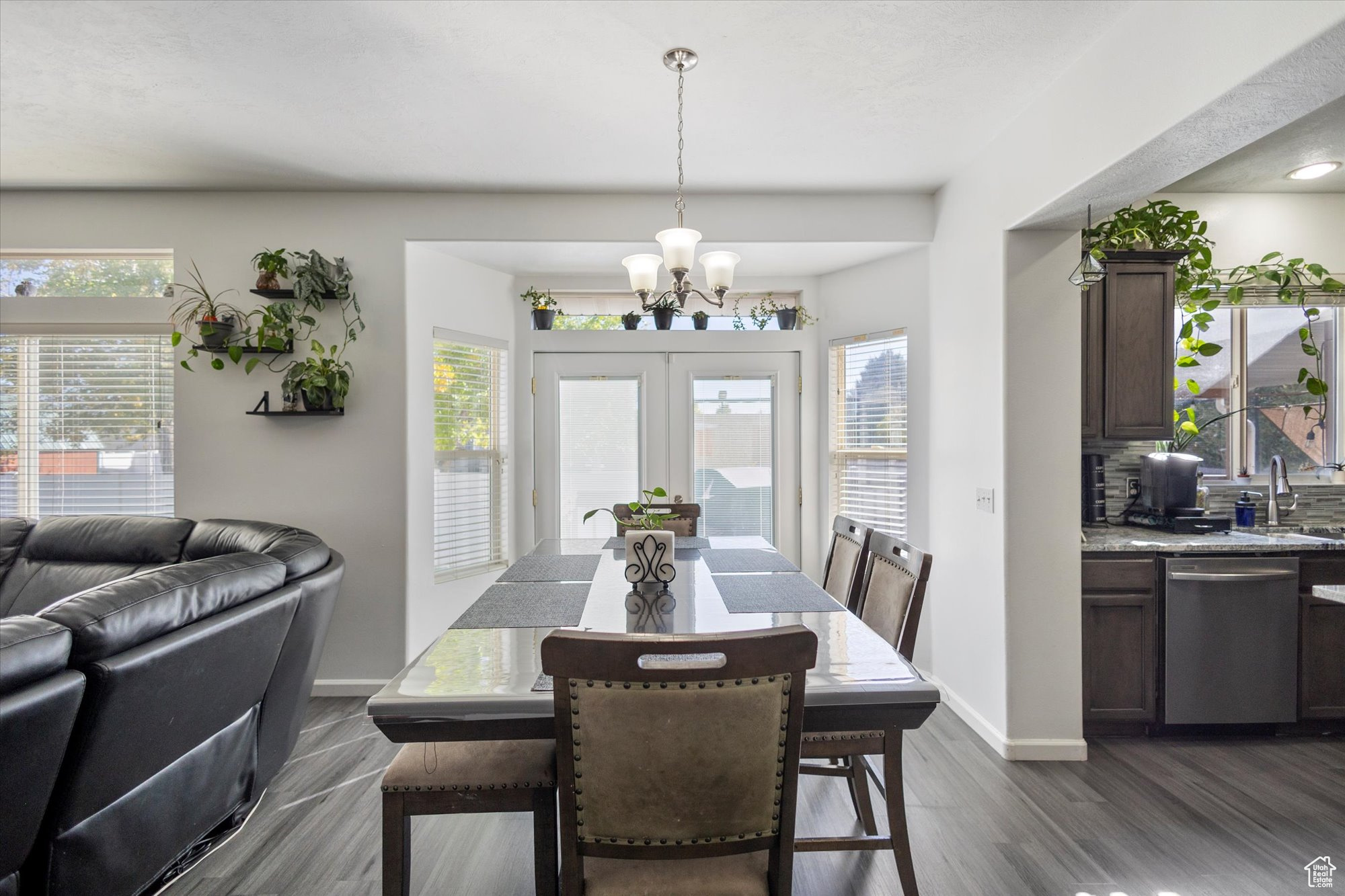 Dining room with a notable chandelier, plenty of natural light, french doors, and dark hardwood / wood-style flooring