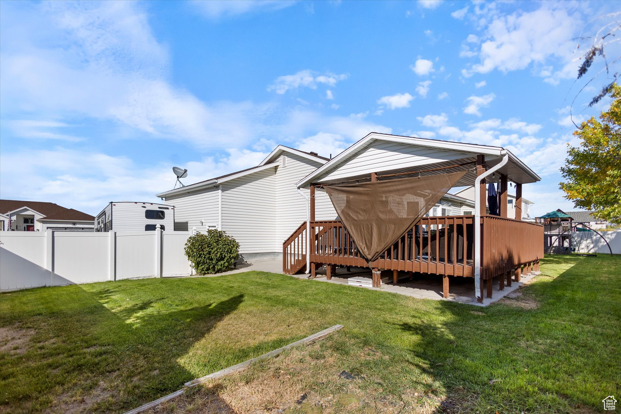 Rear view of property featuring a deck and a lawn