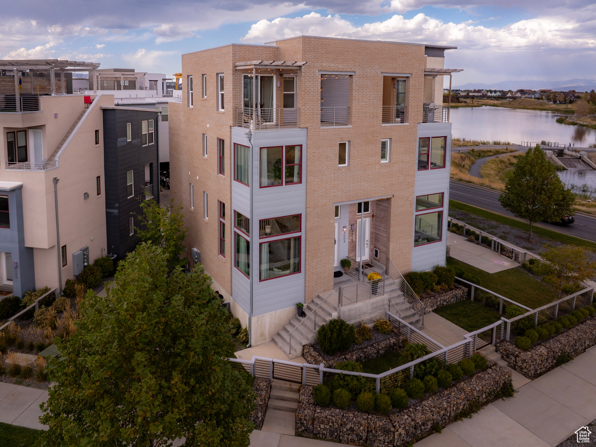 Perched above the breathtaking rotunda at the entrance of Daybreak, removed from the bustle below by a vast green space and its own fenced yard, this luxury townhome welcomes you home.  Step up to your own private hot tub ready deck in the sky and gaze at