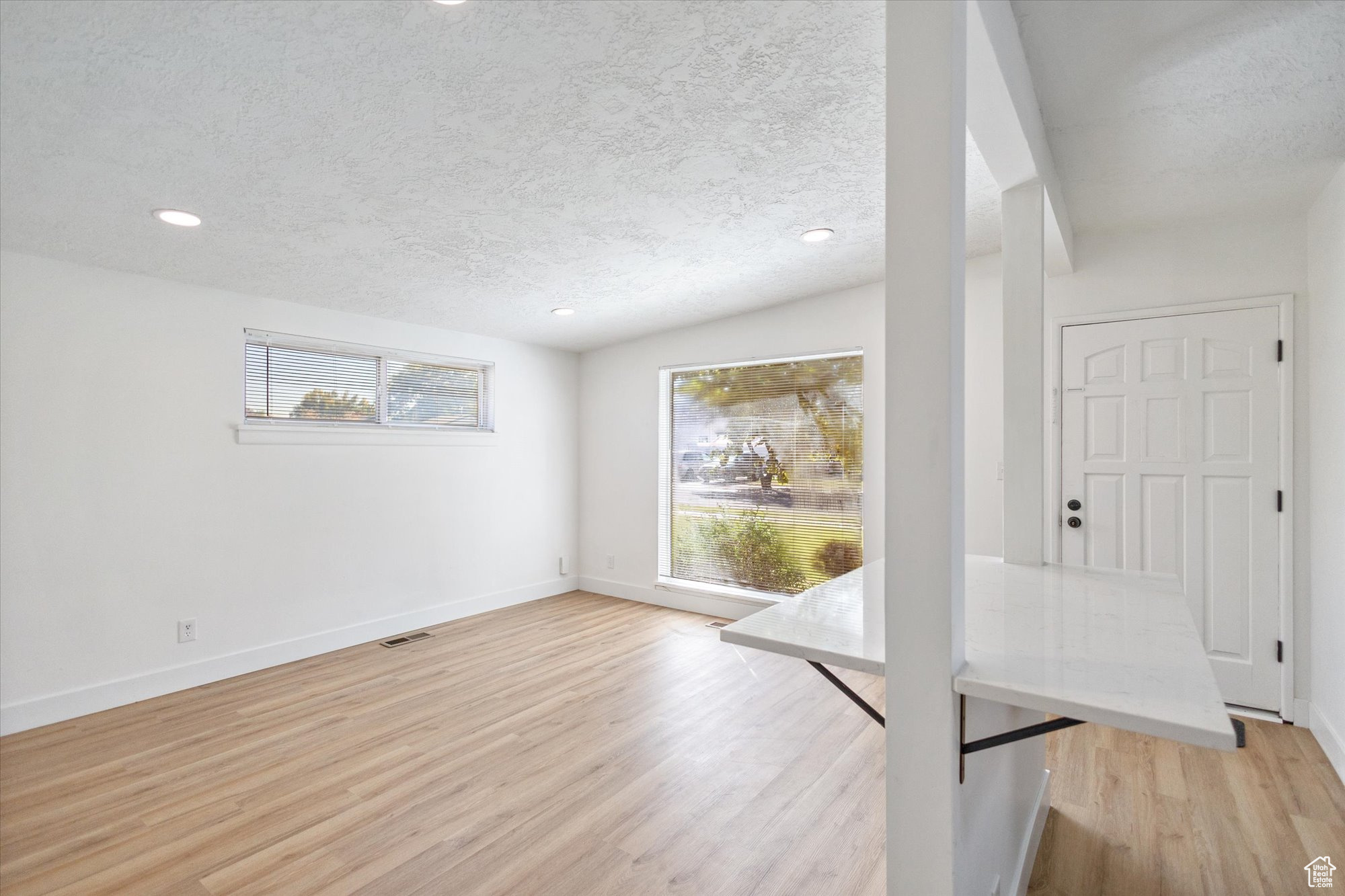 Interior space featuring a textured ceiling and light hardwood / wood-style floors