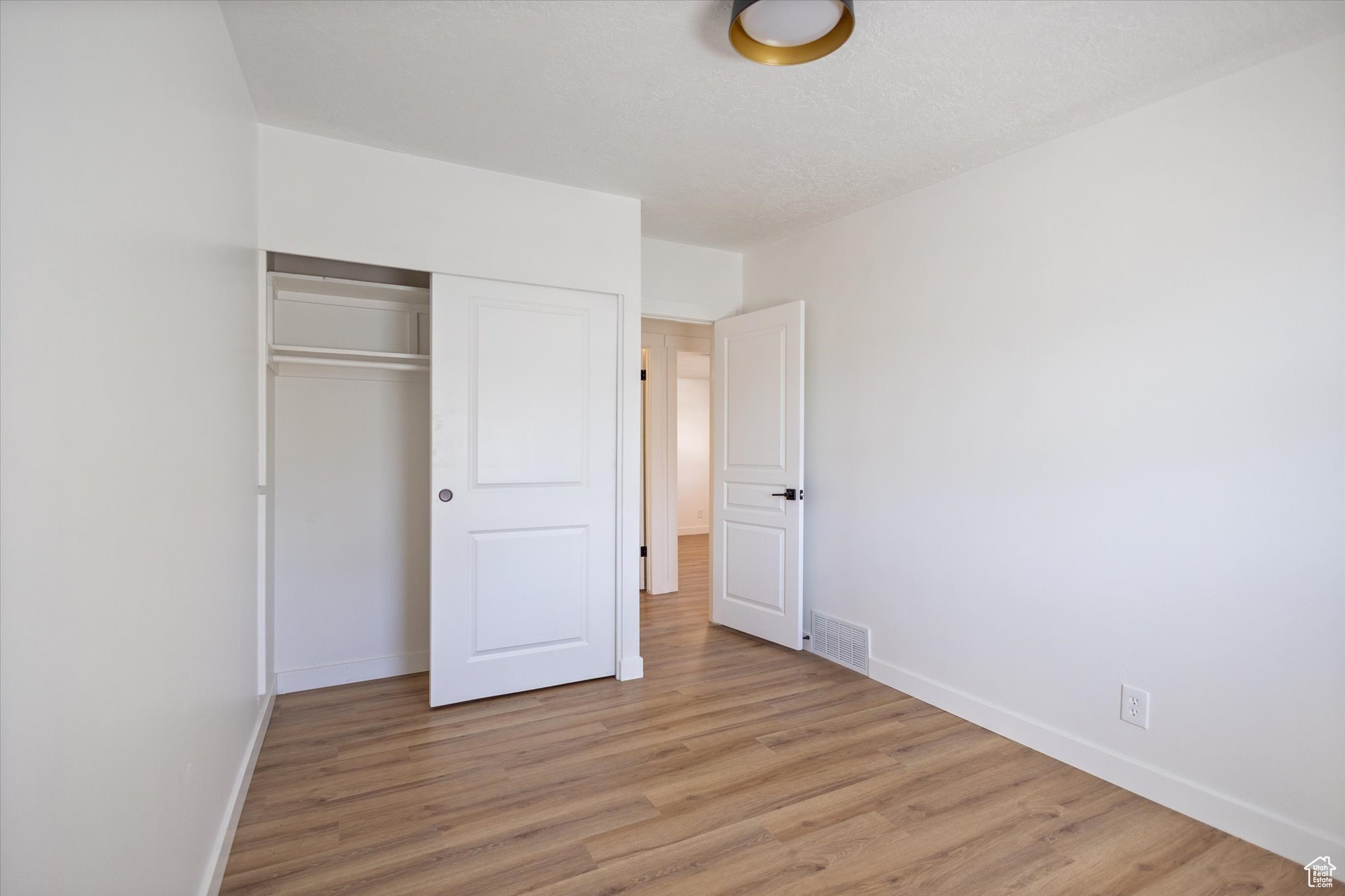 Unfurnished bedroom featuring light hardwood / wood-style flooring and a closet