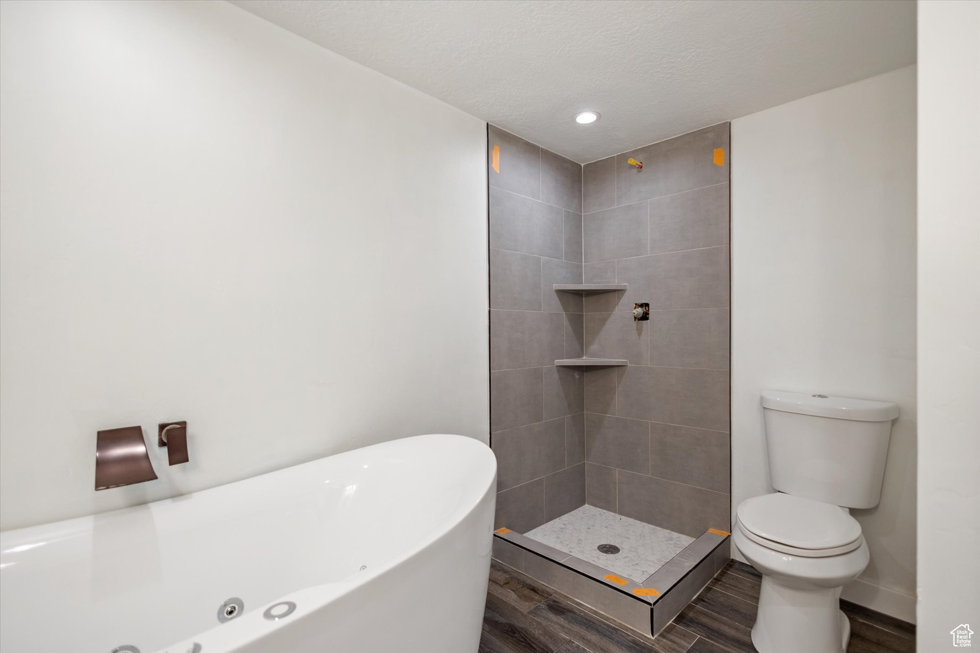 Bathroom featuring shower with separate bathtub, hardwood / wood-style floors, and toilet