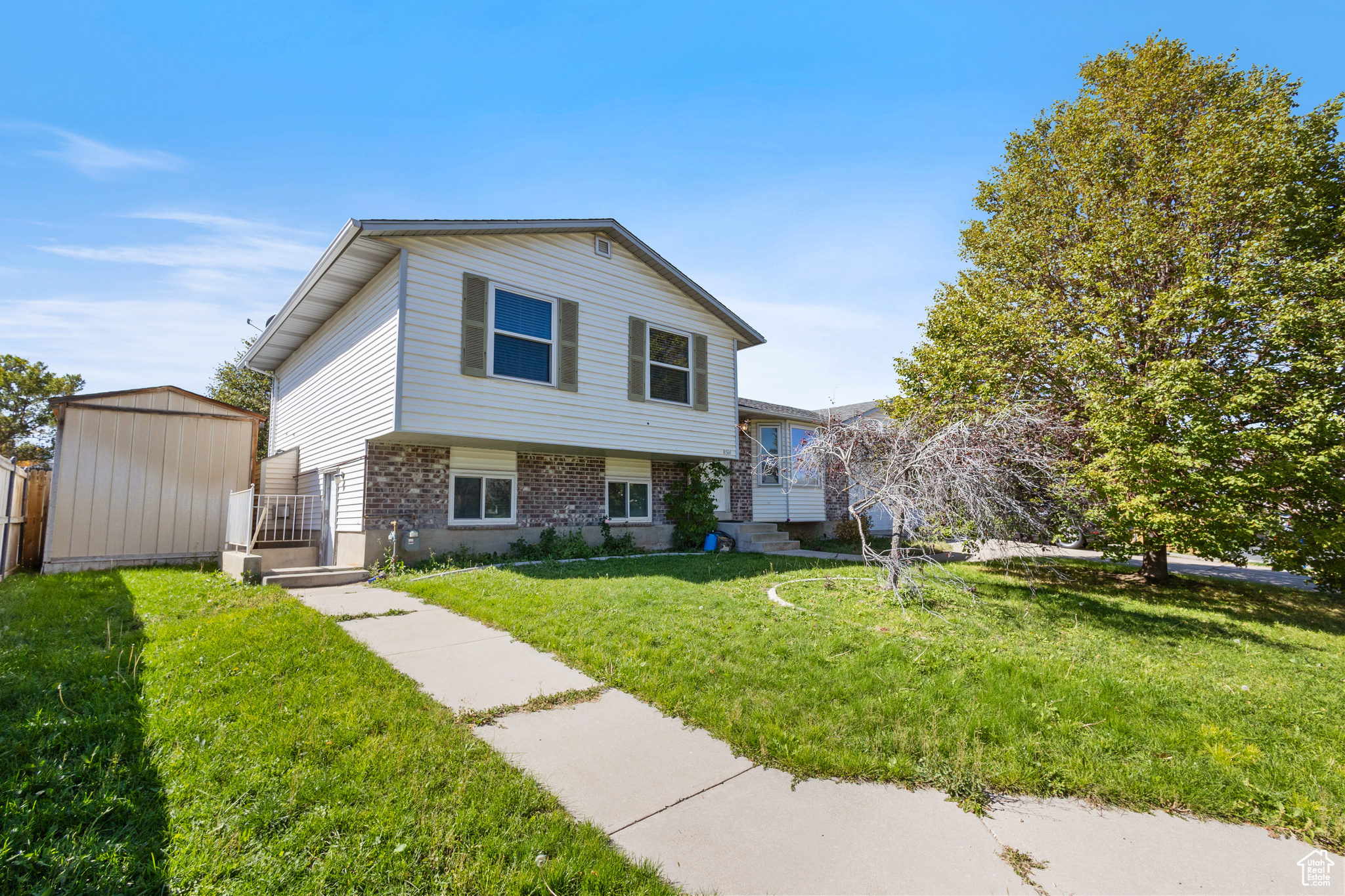 Split level home featuring a shed and a front yard