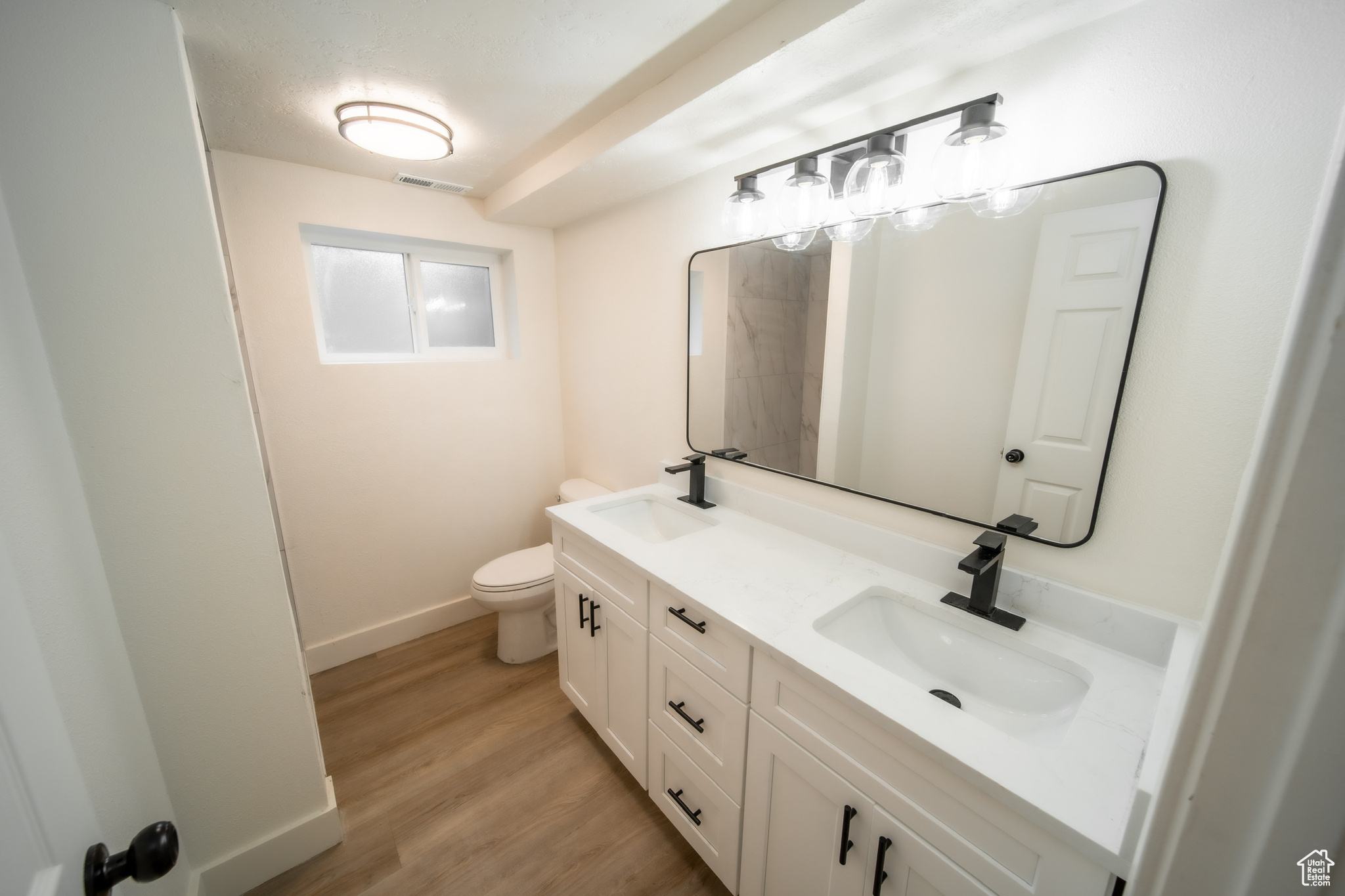 Bathroom with hardwood / wood-style floors, vanity, and toilet