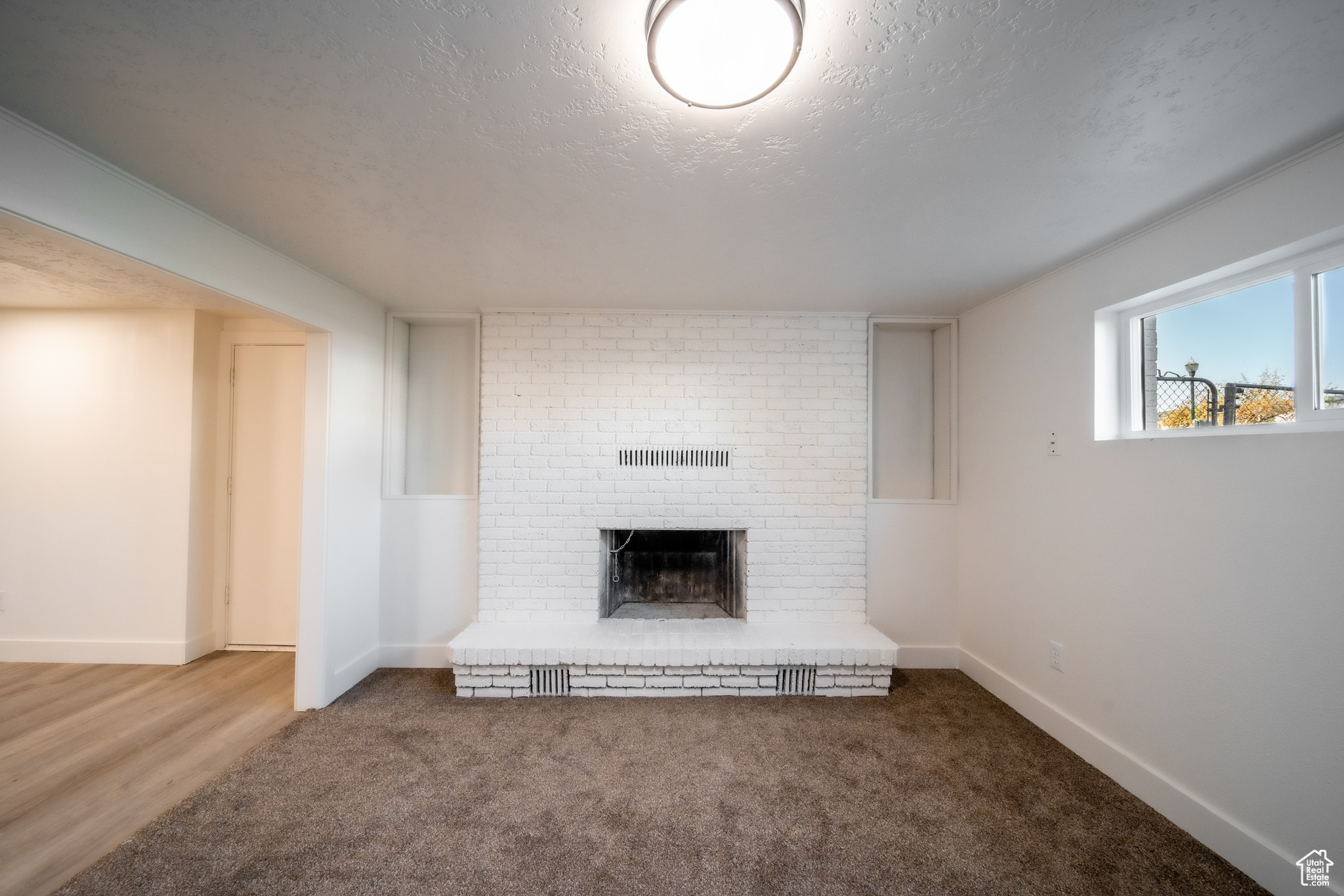 Living room with a textured ceiling, a fireplace, and hardwood / wood-style floors