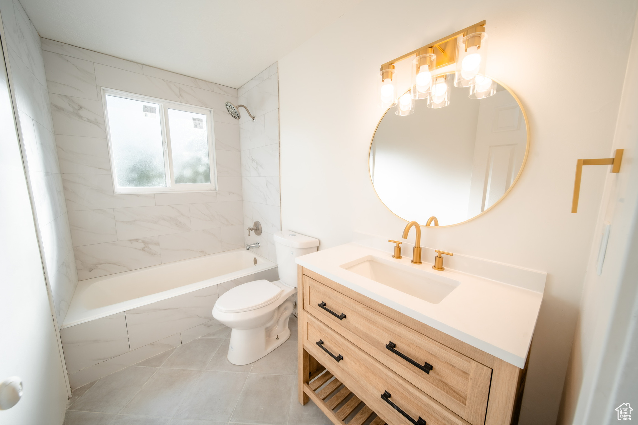 Full bathroom featuring tiled shower / bath, vanity, toilet, and tile patterned floors