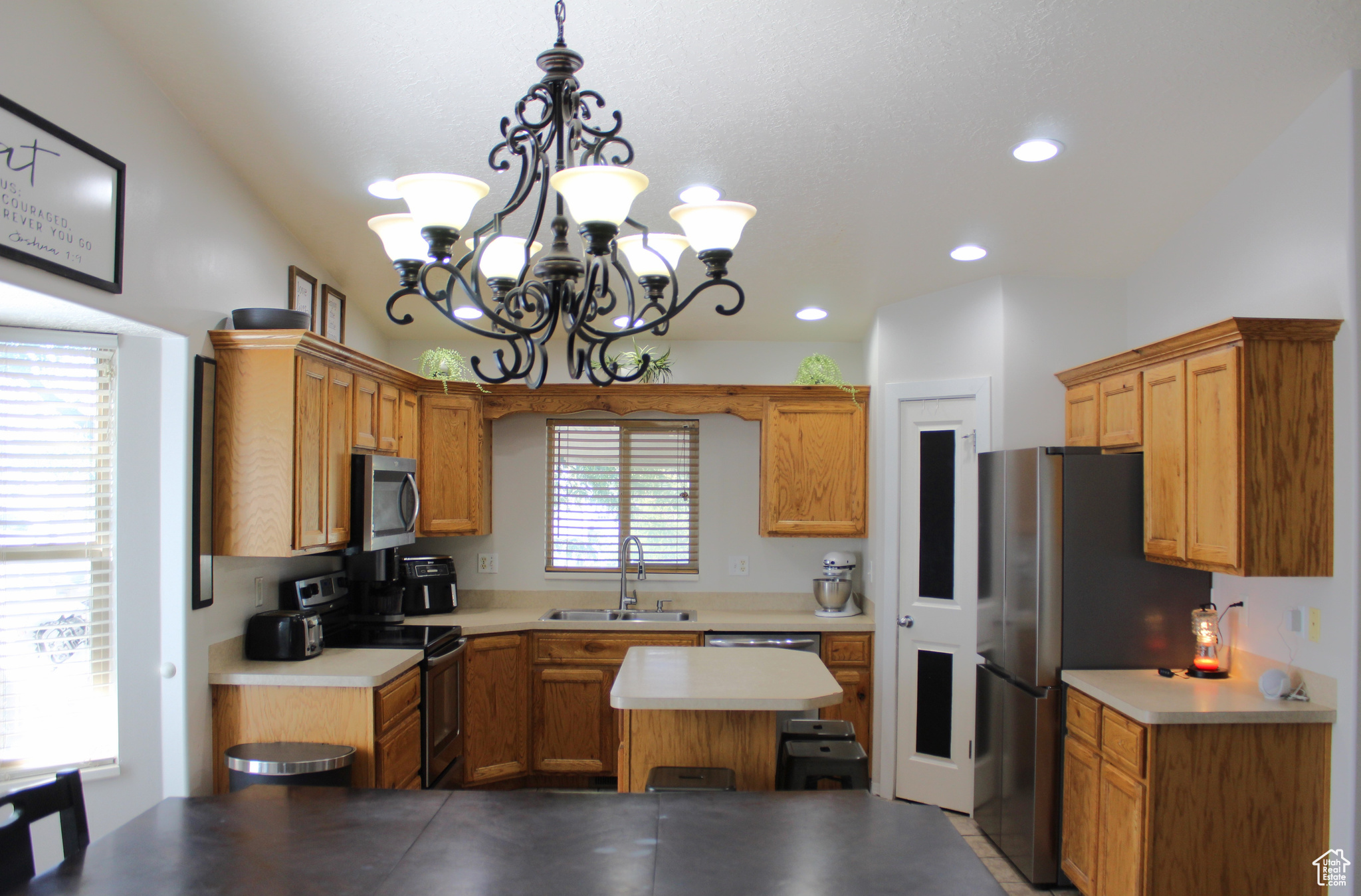 Kitchen featuring a chandelier, stainless steel appliances, sink, and plenty of natural light