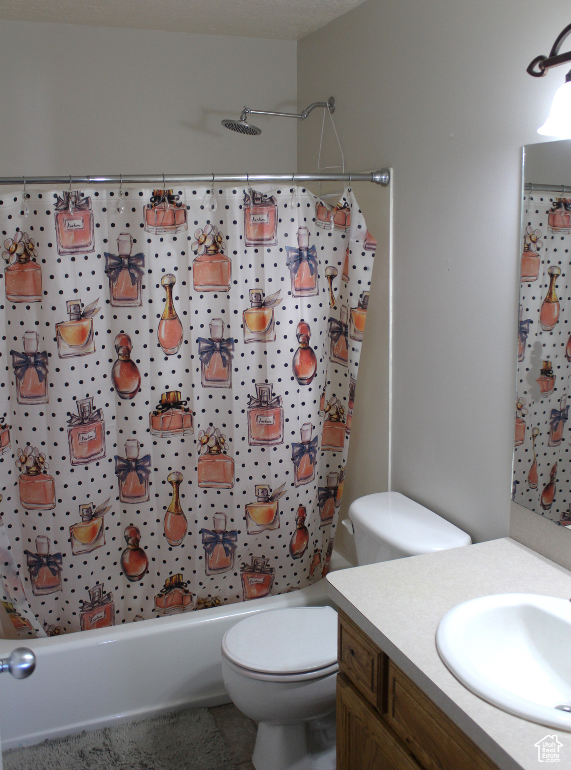 Full bathroom featuring vanity, toilet, and shower / bathtub combination with curtain