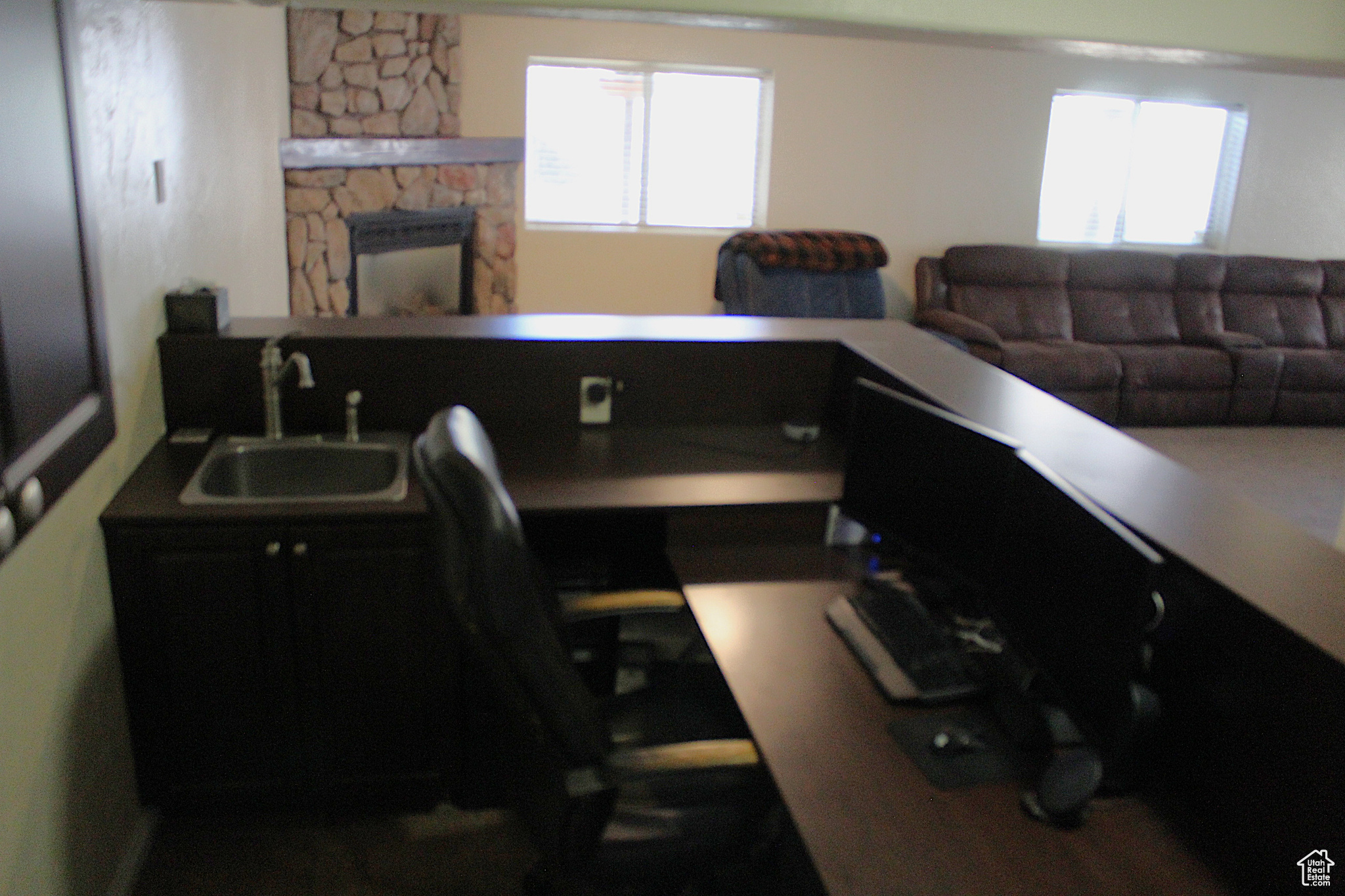 Home office with a stone fireplace and sink