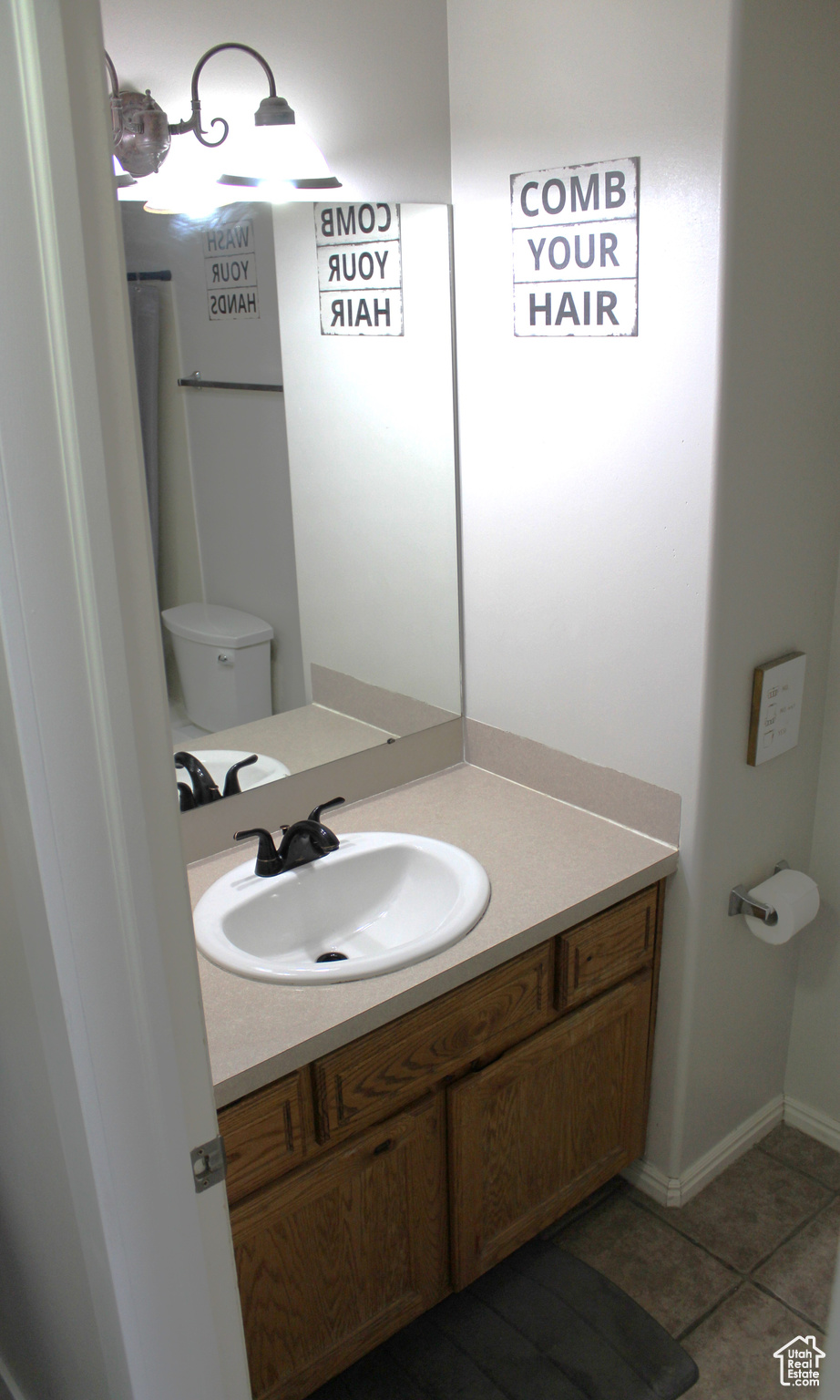 Bathroom with vanity, toilet, and tile patterned flooring