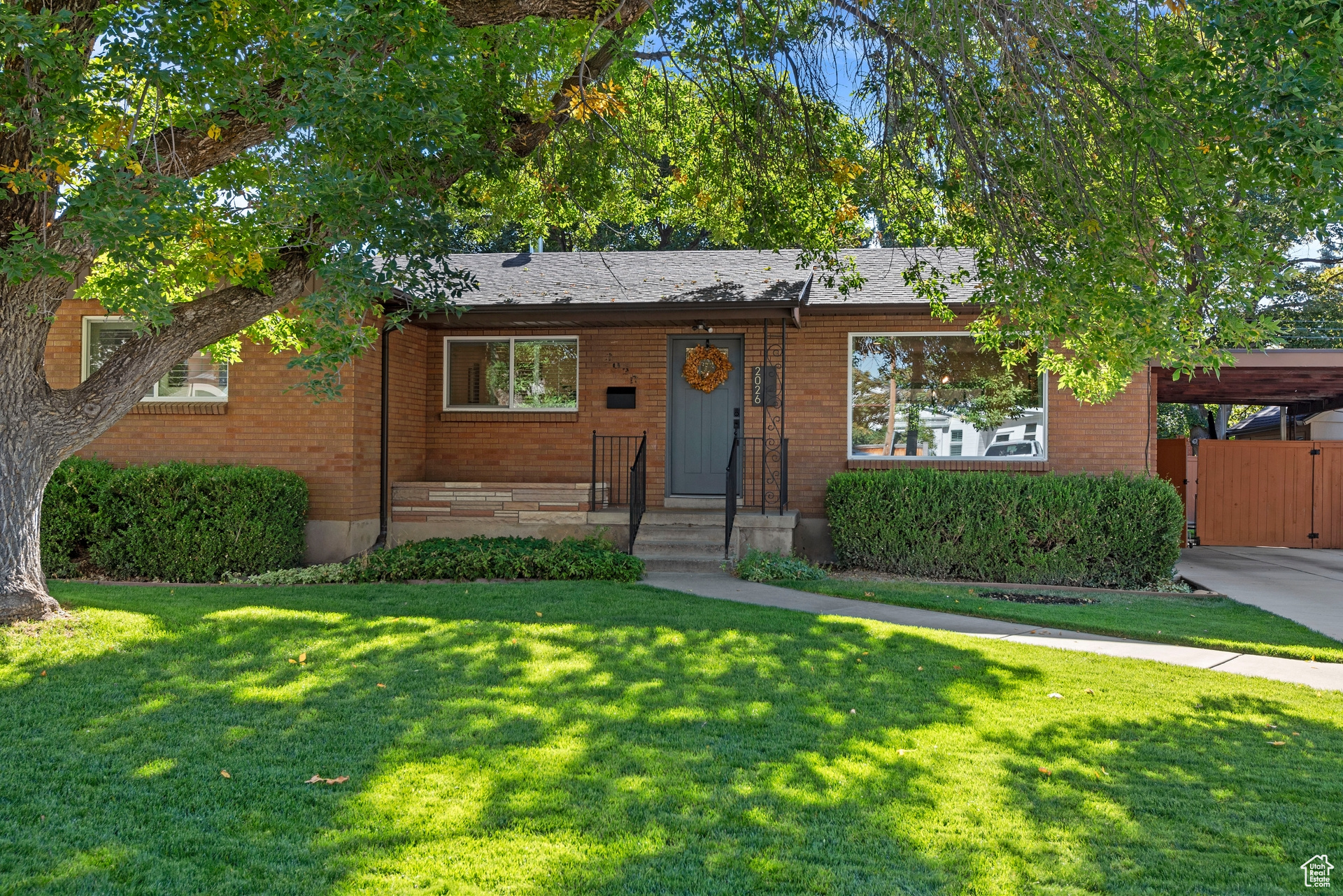 Single story home with a carport and a front lawn