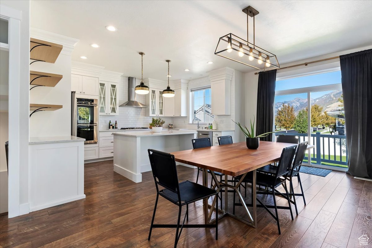 Dining area with dark wood-type flooring, a mountain view, and a wealth of natural light