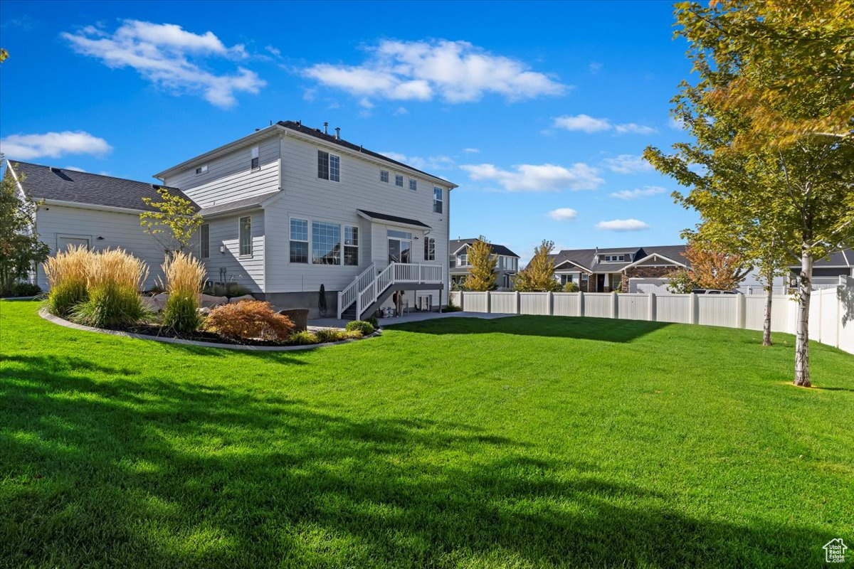 Rear view of property with a yard