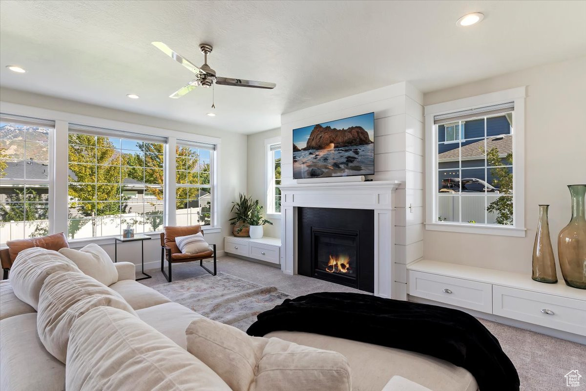 Living room featuring ceiling fan and light colored carpet