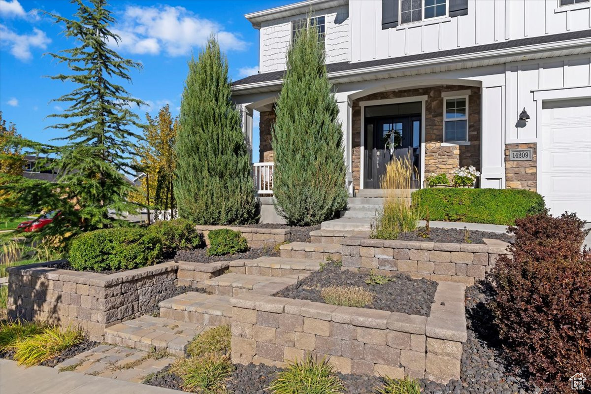 View of exterior entry featuring a porch and a garage