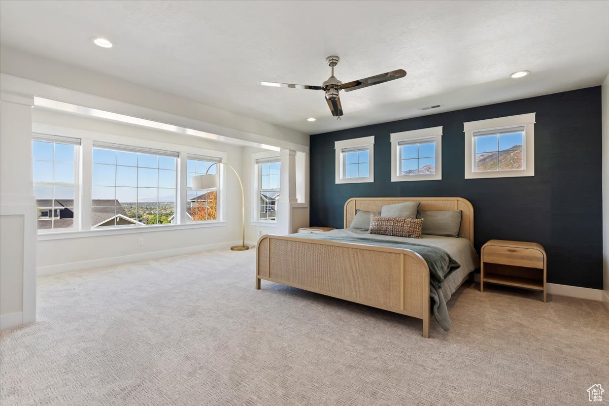 Carpeted bedroom featuring ceiling fan