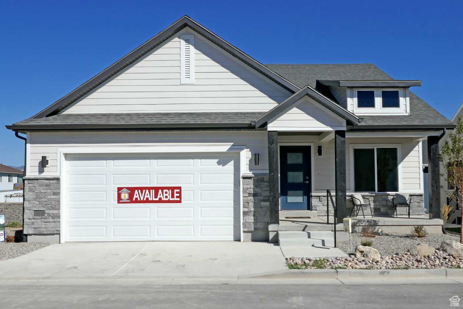 This Craftsman-style home features an attached 2-car garage, large porch, and stone accents