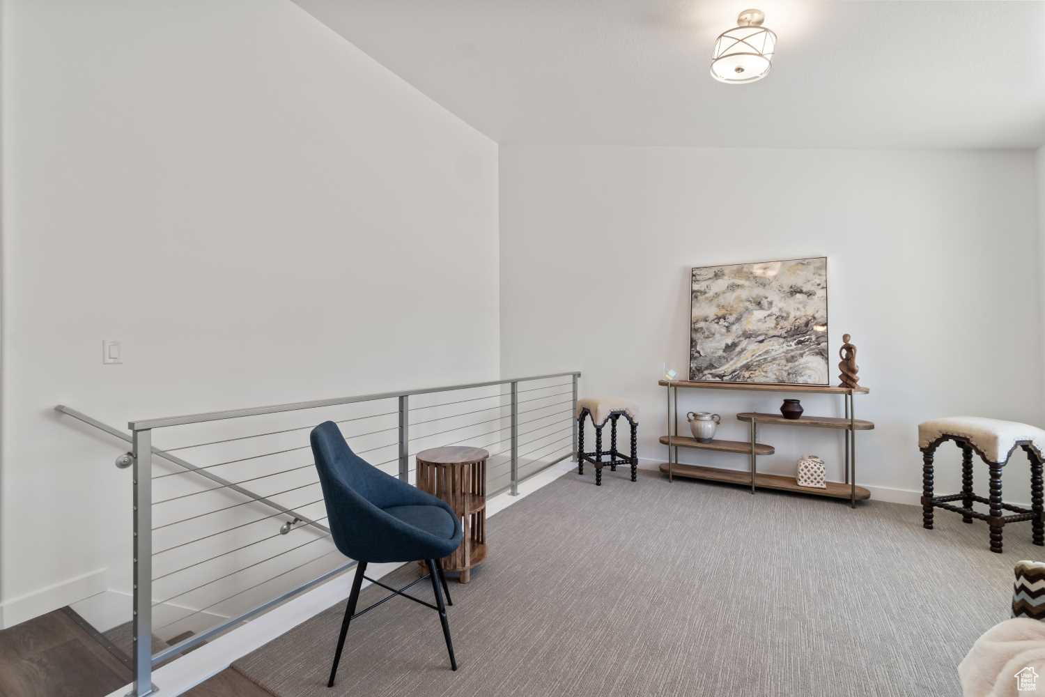 A formal living room welcomes you into the home, featuring gorgeous cable railing along stairs to basement