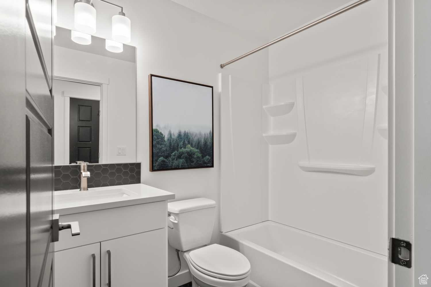 The hall bath is gorgeous with upgraded cabinets, lighting, and tile on floor and backsplash