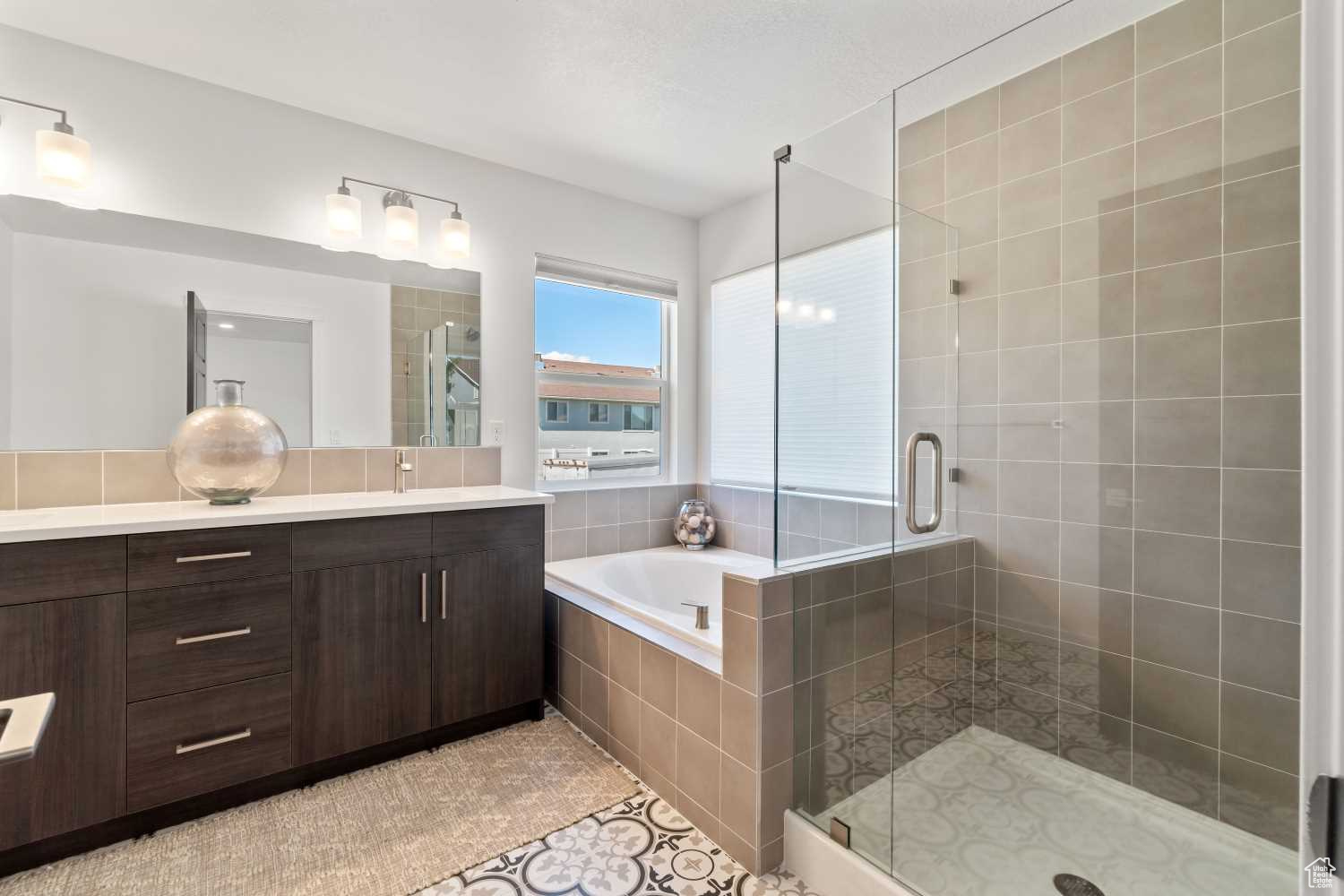 Primary Bathroom features separate tub and shower, double sinks, upgraded tile and more