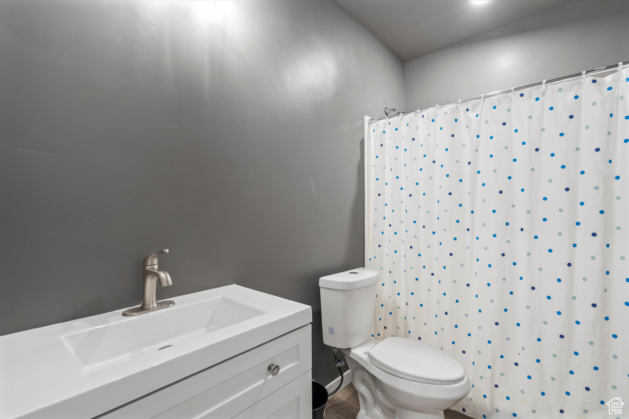 Full bathroom in basement with curtained shower, vanity, and toilet