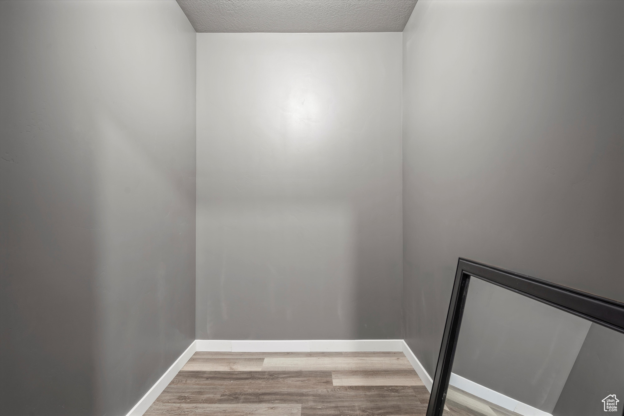 Walk-in closet in bedroom #6 flooring and a textured ceiling