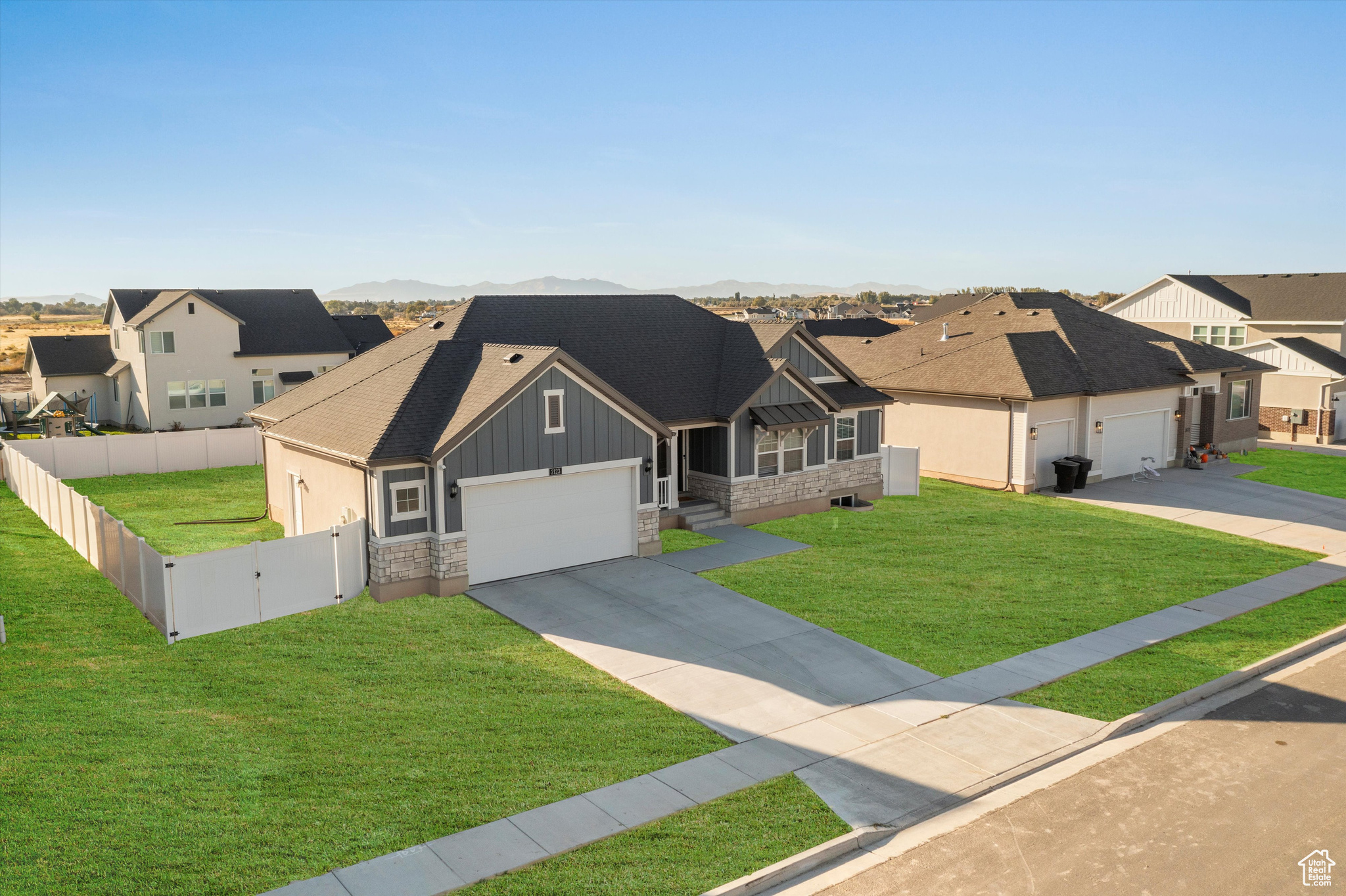 Craftsman-style home with a garage and a front lawn. Photoshopped with grass