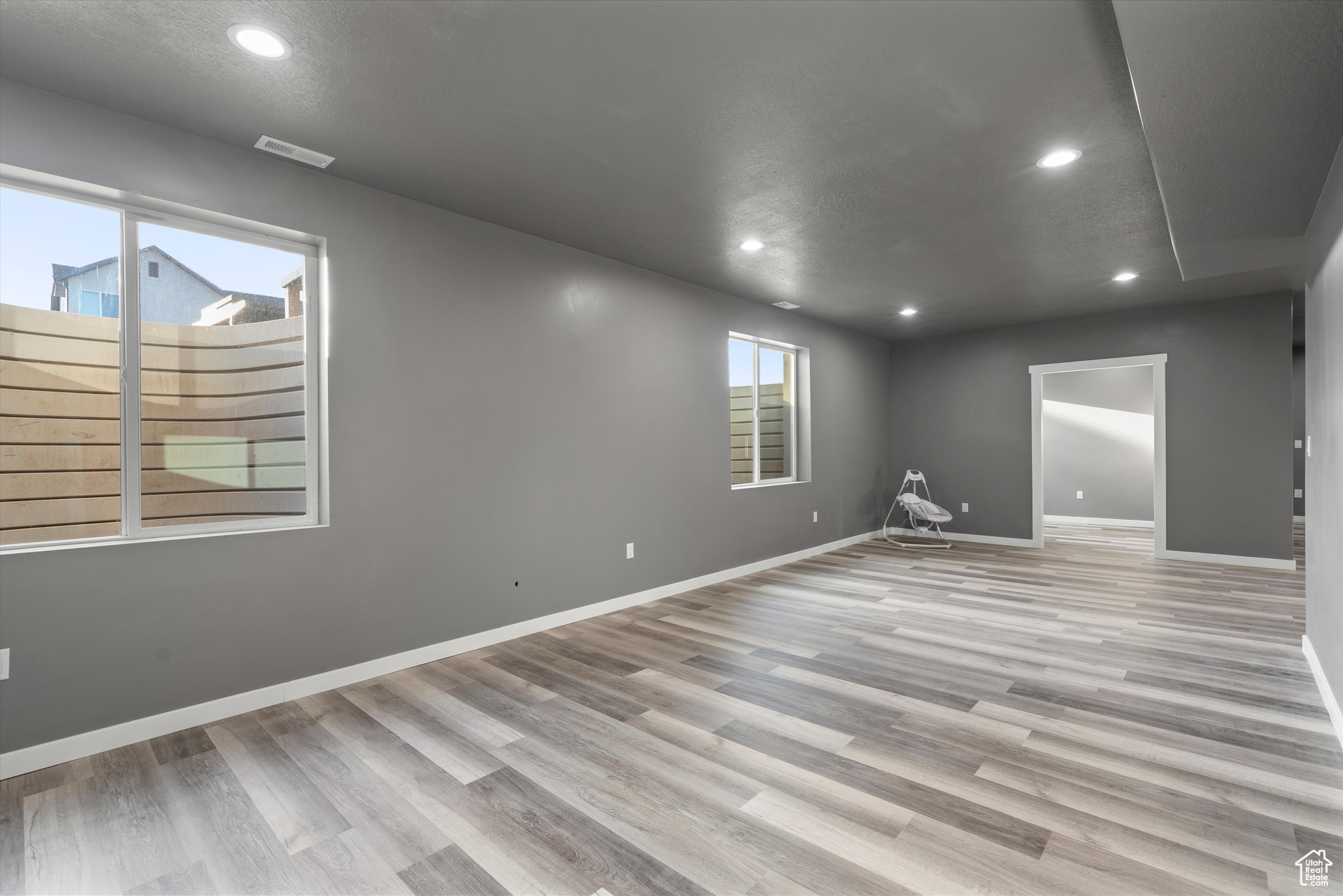 Basement family room with textured ceiling and LVP flooring.