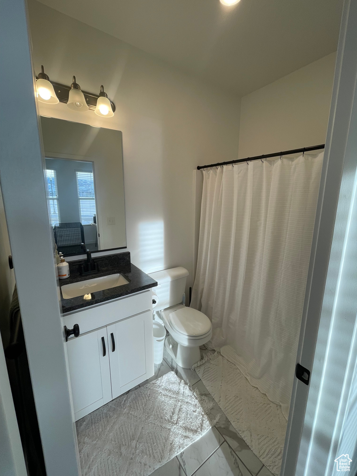 Main floor Bathroom with walk in shower, vanity, and toilet