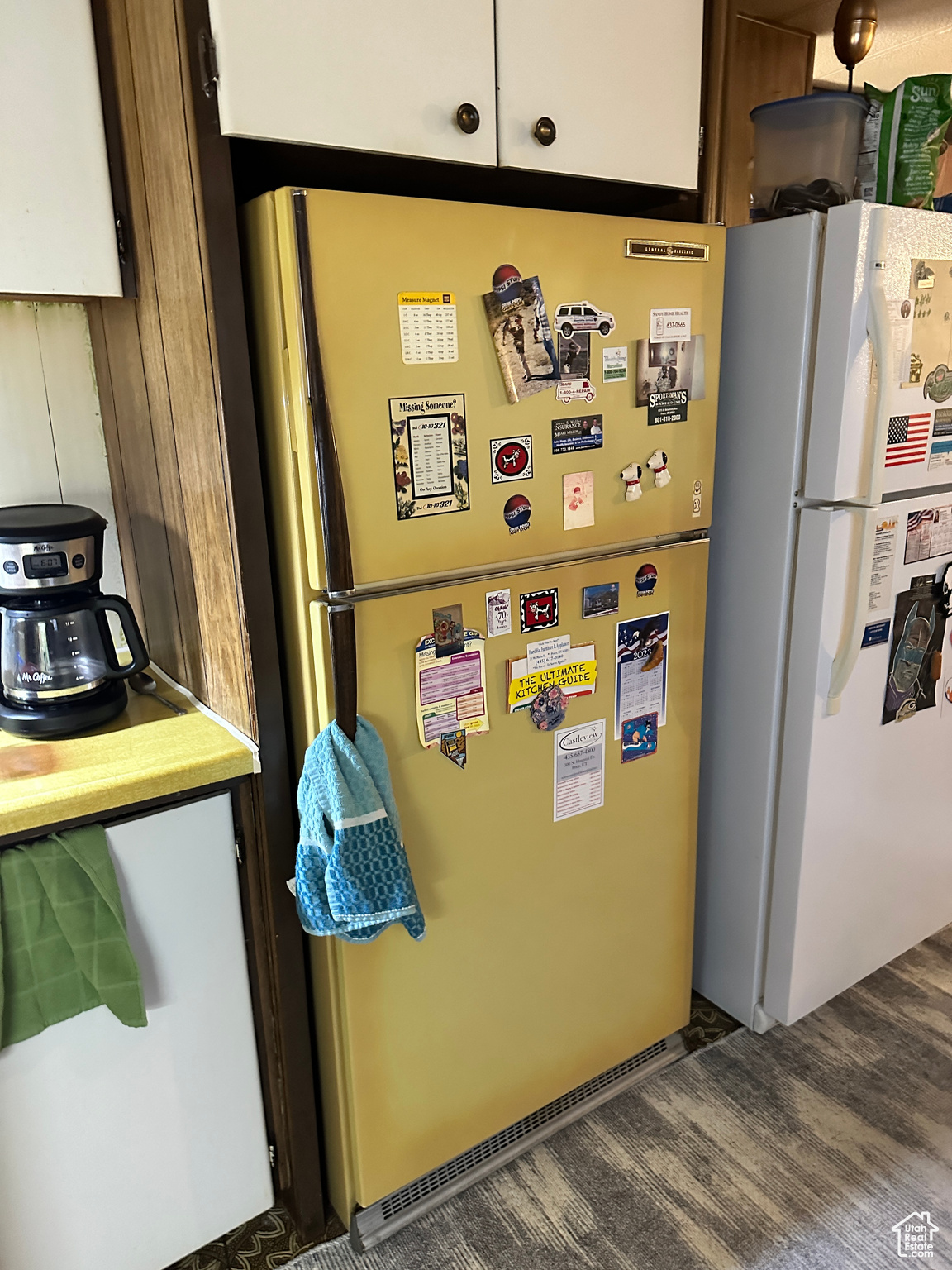 Kitchen featuring white refrigerator, dark wood-type flooring, white cabinetry, and stainless steel refrigerator