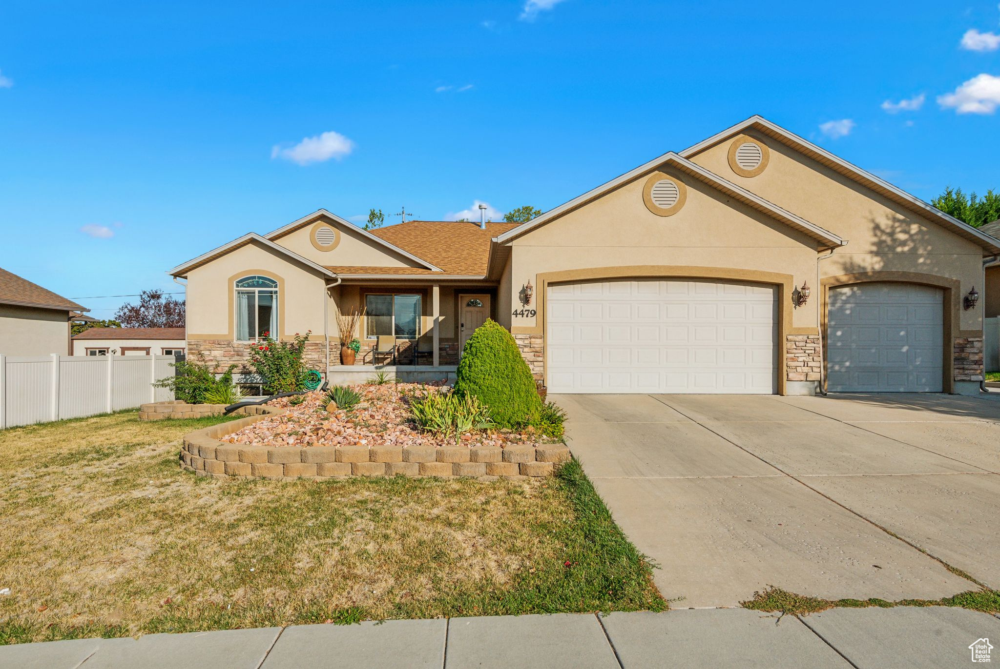 Single story home with a garage and a front lawn