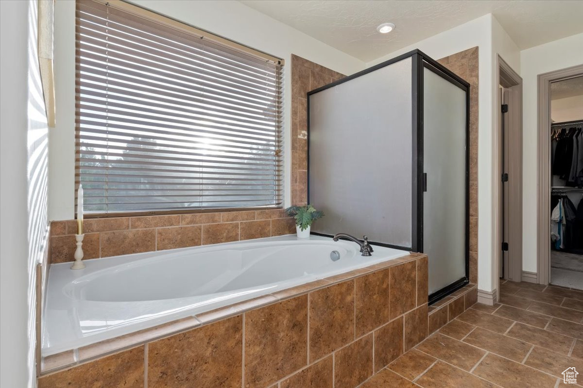 Bathroom featuring tile patterned flooring and independent shower and bath