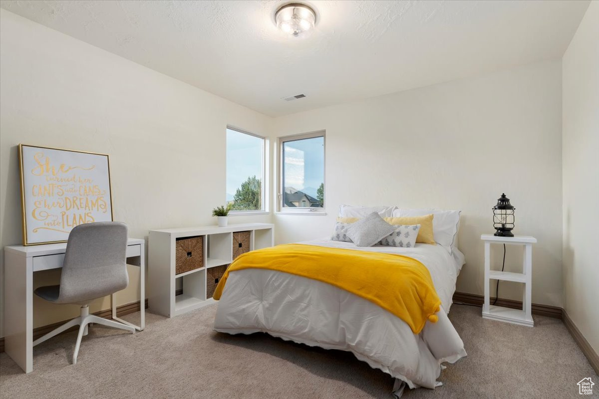 Bedroom featuring light carpet