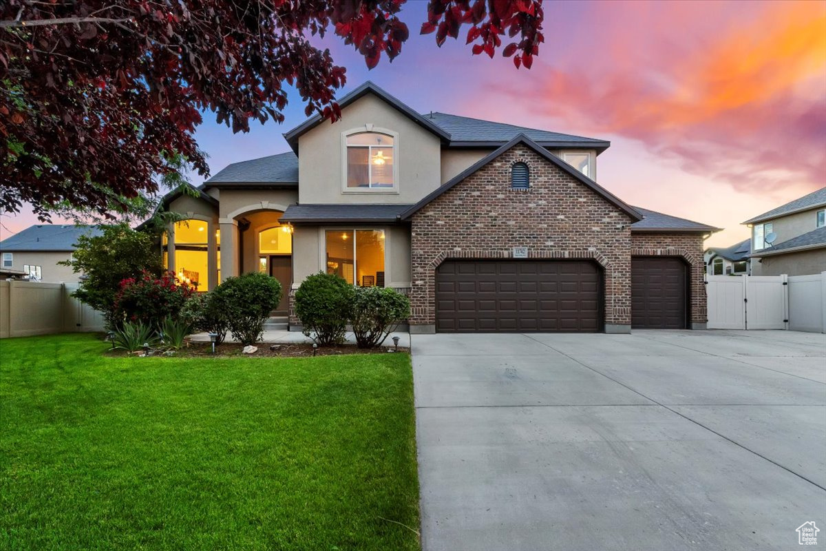 View of front of home featuring a yard and a garage