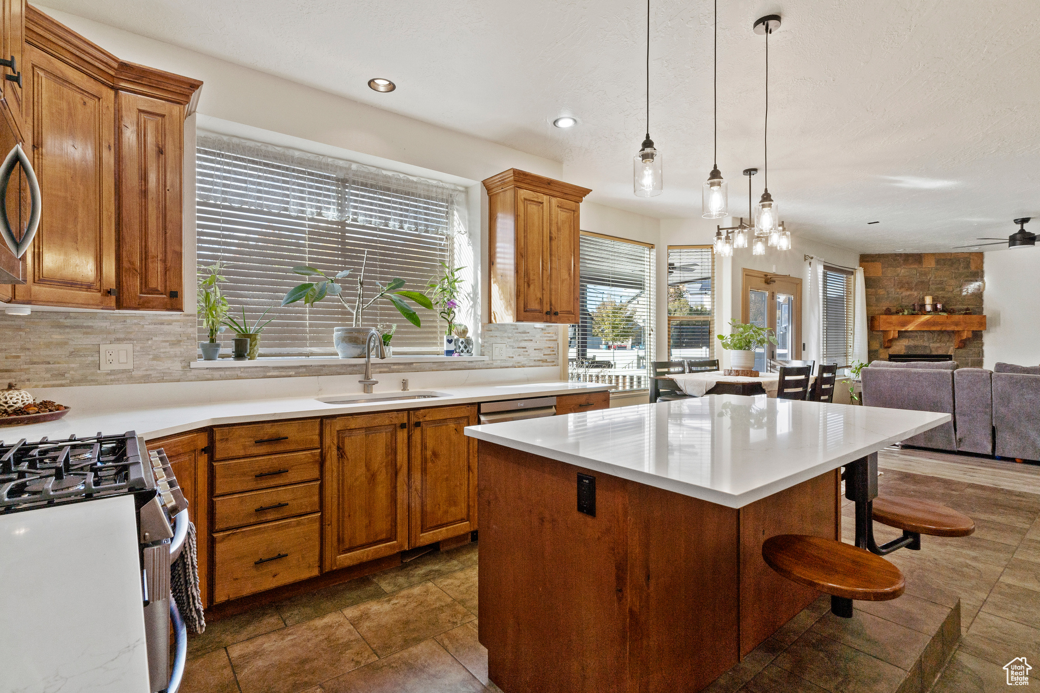 Kitchen with a center island, NEW gas range oven, a fireplace, NEW tasteful backsplash, and NEW light fixtures