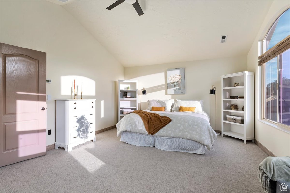 Bedroom with light carpet, high vaulted ceiling, and ceiling fan