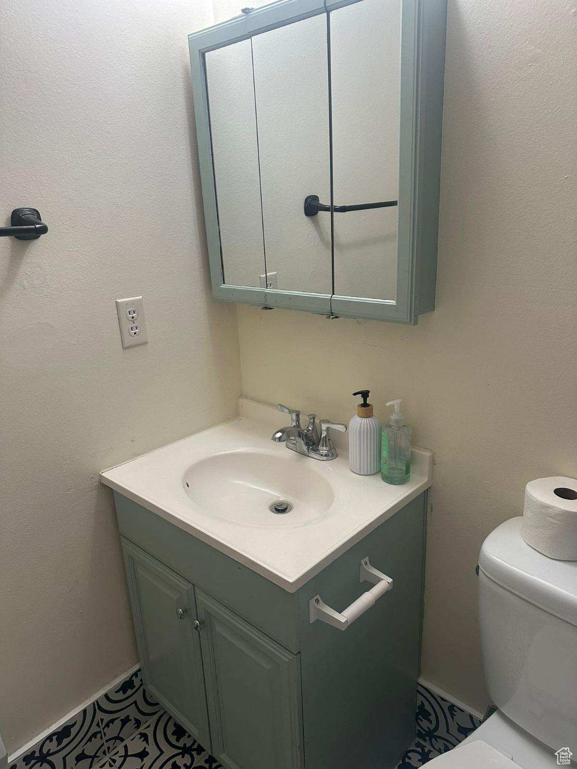 Bathroom with tile patterned floors, vanity, and toilet