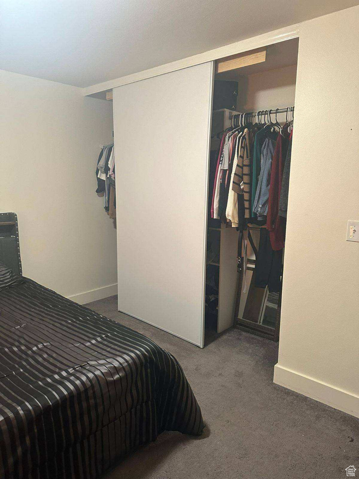 Bedroom featuring dark carpet and a closet