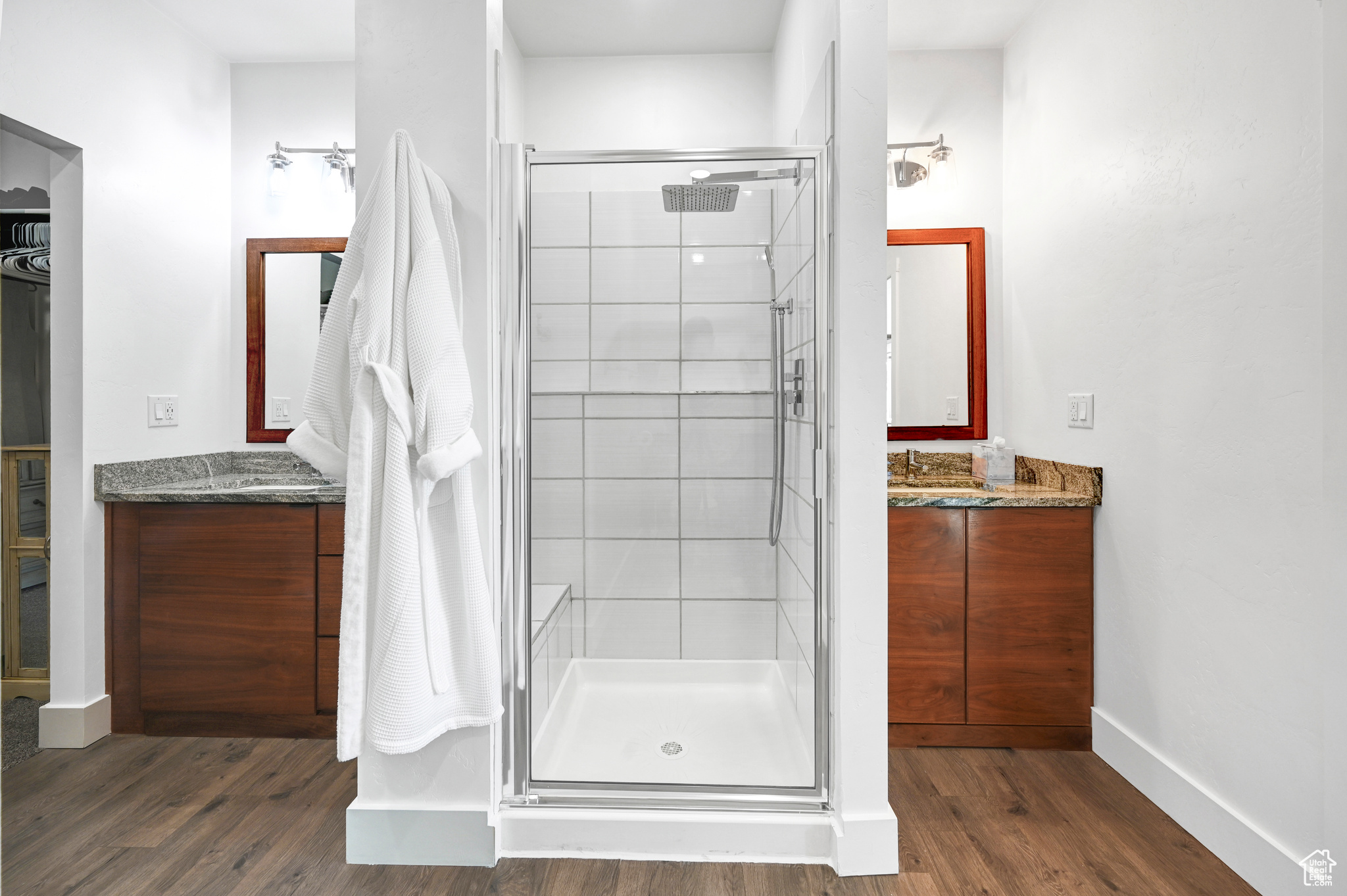 Bathroom with wood-type flooring, vanity, and a shower with door