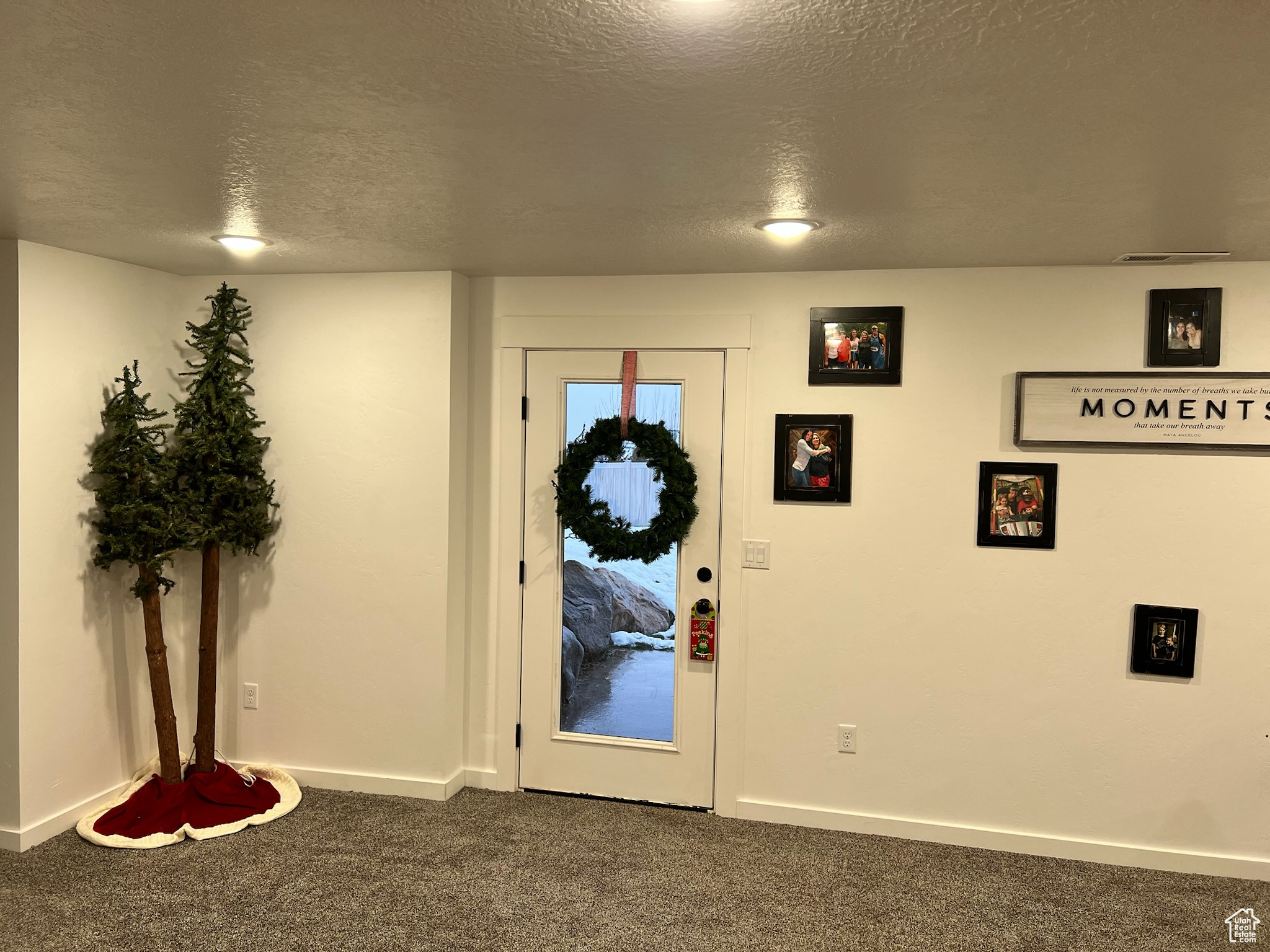 Carpeted entryway with a textured ceiling