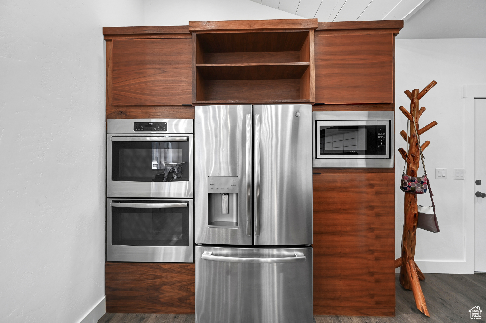 Kitchen featuring stainless steel appliances and dark hardwood / wood-style flooring