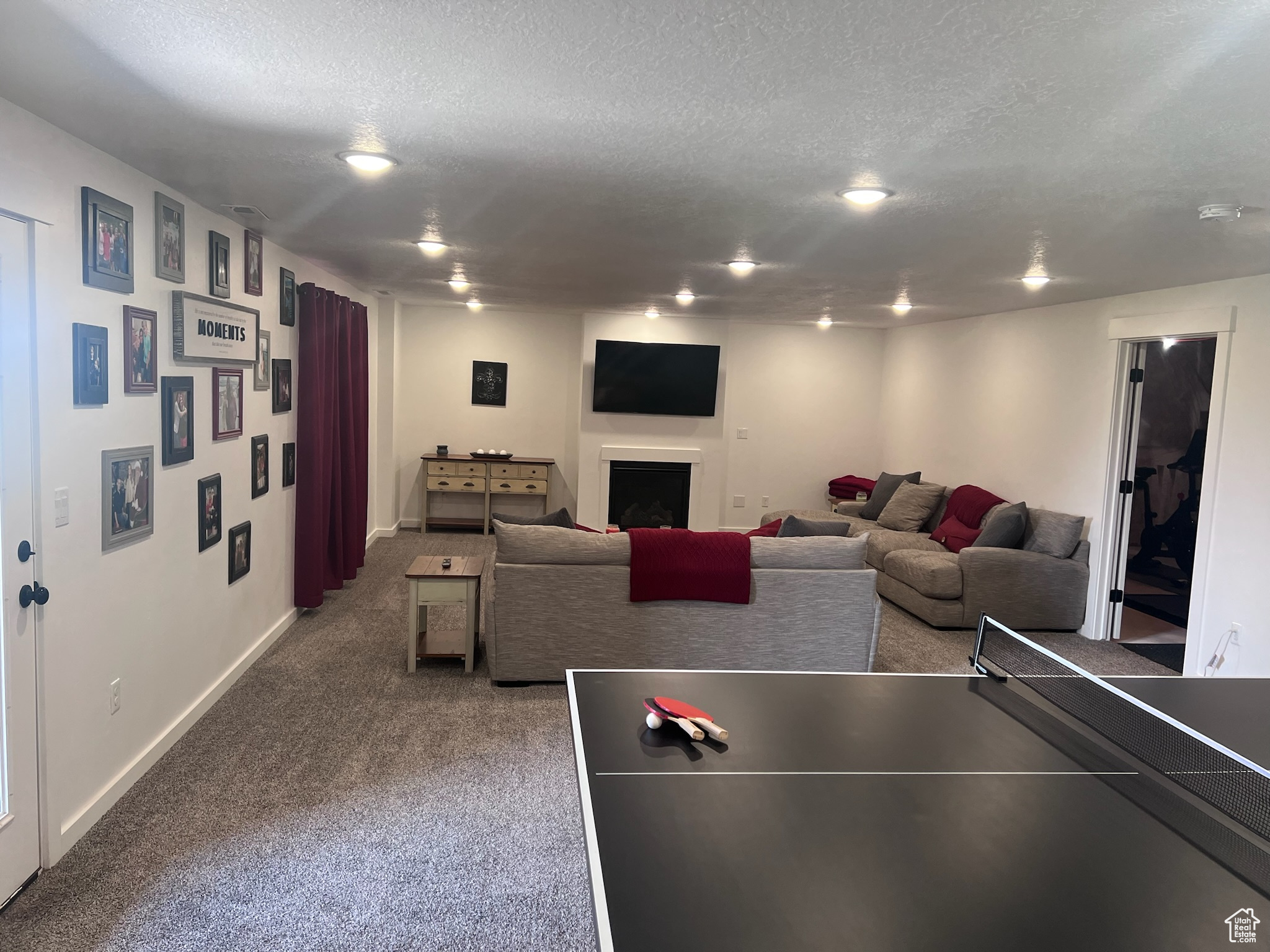 Game room featuring dark colored carpet and a textured ceiling