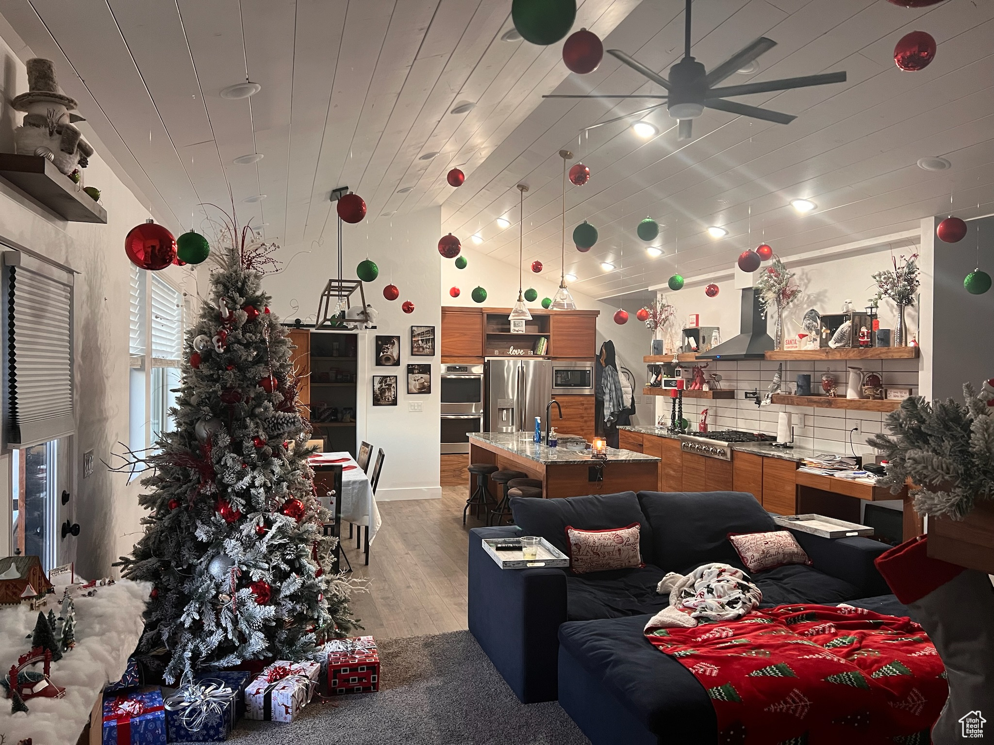 Interior space with ceiling fan, light hardwood / wood-style flooring, wood ceiling, sink, and high vaulted ceiling