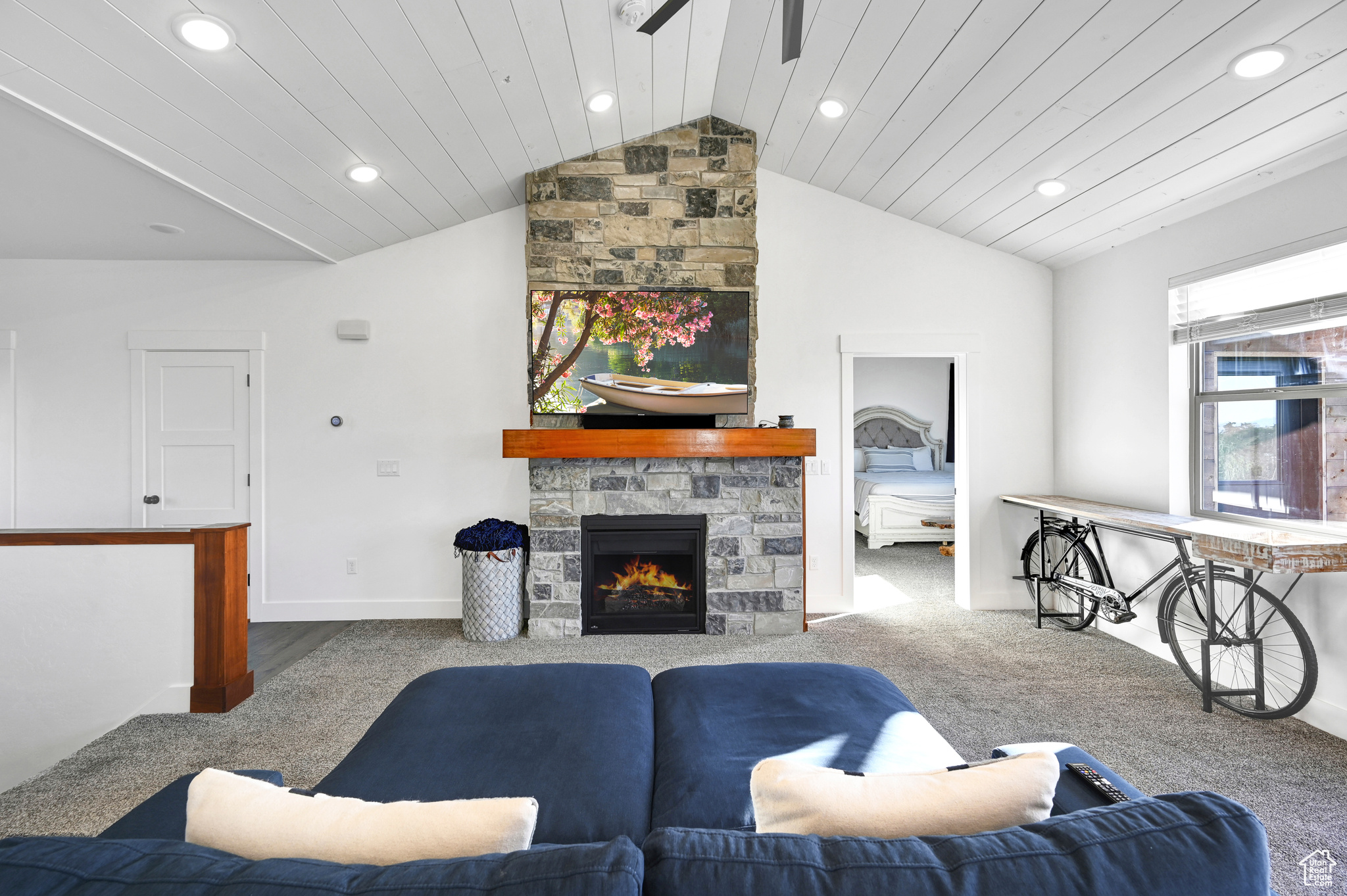 Living room with lofted ceiling, a fireplace, and light colored carpet