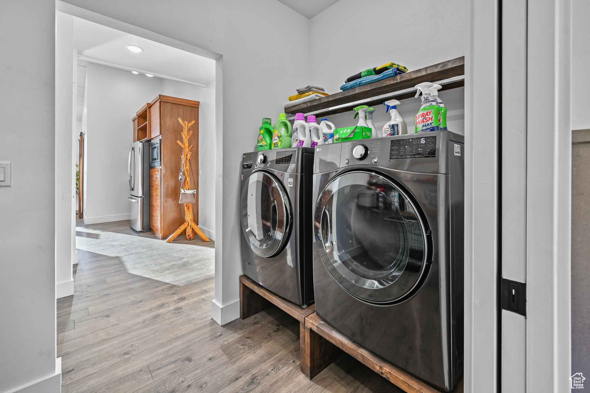 Laundry area with hardwood / wood-style flooring and washer and dryer